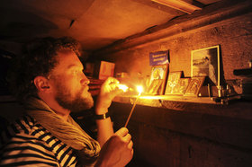 Sylvain Tesson allumant une bougie devant des icônes russes - © Photo Thomas Goisque